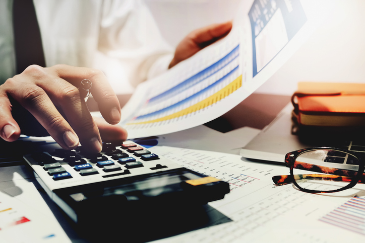 A man's hands is busy in calculating an effective tax plan to reduce tax liabilities and maximize tax credits and incentives.