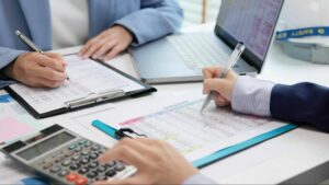 GST HST compliance Canada with professionals reviewing tax documents, financial reports, and calculations in an office setting.
