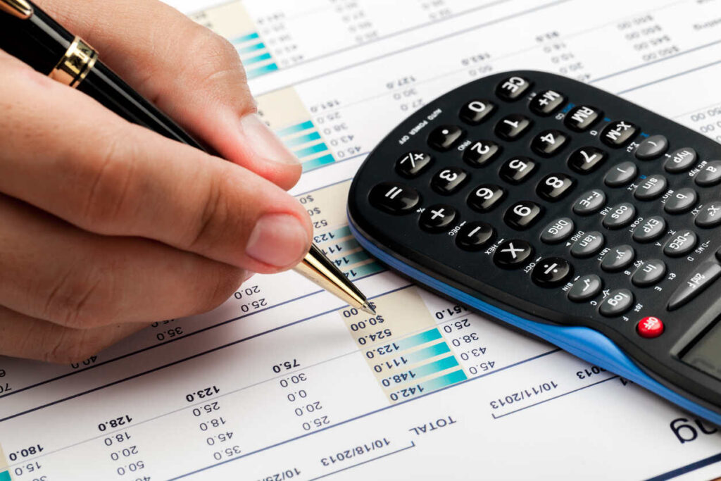 Professional reviewing financial statements and using a calculator to turn financial data into a clear story for banks, investors, and team decision-making.